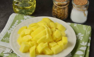 Snijd de aardappelen nu in kleine blokjes. We sturen het met de linzen het water in.
