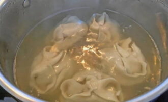 Espereu fins que el brou torni a bullir i reduïu la temperatura. Cuini el manti durant 10 minuts, tapant la paella amb una tapa.
