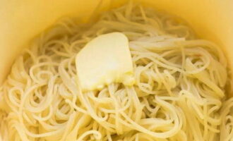 Doe de spaghetti in een kom en breng op smaak met boter.