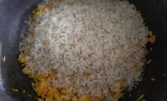 Apoi, întindeți orezul în tigaie într-un strat uniform. Sarați și stropiți cu condimente aromate după gust. Umpleți cu apă și gătiți la foc mic până când umezeala se evaporă.