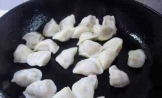 Verhit een koekenpan met plantaardige olie en doe er dumplings in.