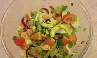 I en stekpanna, stek vitlöken i olja tills en ljus arom visas. Stek tärningar av vitt bröd här. Blanda avokado, picklad lök, kex, tomatbitar, örter och sallad i en djup skål. Smaka av med peppar, tillsätt apelsinjuice och rör om.