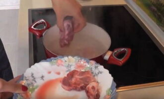A leveshez először a sertéscsontokat forraljuk fel. Egy lábosban felforralunk 3 liter vizet, beletesszük a jól megmosott csontokat, és közepes lángon egy órát főzzük. Távolítsa el a habot a húsleves felületéről.