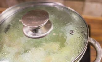 Wanneer de dumplings naar de oppervlakte drijven, dek je de pan af met een deksel, zet je de temperatuur iets onder medium, het water moet koken.