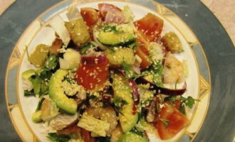 Lägg den beredda grönsaken på en tallrik med skaldjur. Strö över sesamfrön. En ljus och aptitretande sallad med avokado och räkor är klar. Ta för dig!