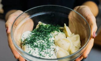Plaats de dumplings met een schuimspaan in een kom. Breng op smaak met zure room. Bestrooi met gehakte kruiden. Verwen uw dierbaren. Eet smakelijk!