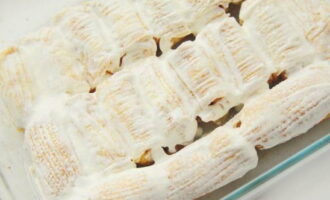 Ungeți generos clătitele cu smântână pe toate părțile. Se presară cu zahăr. Acoperiți tava cu folie de copt. Pune la cuptor. Se coace la 150 de grade timp de 40 de minute. Scoateți folia și coaceți până se rumenesc încă 20 de minute.