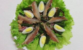 Pagkatapos ay maingat at maganda ayusin ang anchovy fillet na may mga quartered na itlog.