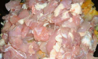 Afegiu trossos de pollastre a les verdures fregides, barregeu-ho tot i fregiu-ho a foc fort sota una tapa tancada fins que tot el líquid s'hagi evaporat completament.