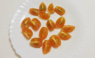 Banlawan ang mga kamatis ng cherry, tuyo ang mga ito gamit ang isang napkin at gupitin ang mga ito sa parehong quarter ng mga itlog.