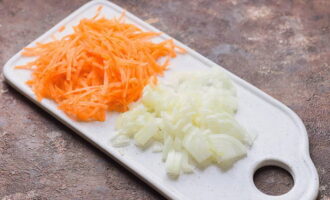 Habang nagluluto ang sopas, gupitin ang peeled na sibuyas sa maliliit na cubes at i-chop ang mga karot sa isang magaspang na kudkuran. 