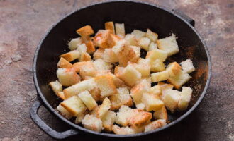 Gupitin ang mga hiwa ng tinapay sa mga cube, ibuhos sa langis ng gulay, iwiwisik ang mga pampalasa at ilagay sa isang preheated oven sa loob ng 15 minuto.