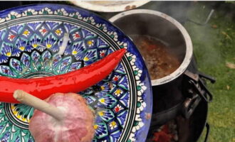 Open na deze tijd het deksel van de ketel en verwijder de knoflook en peper.