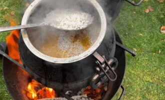 Spoel de rijst meerdere keren af ​​met koud water.Leg het vervolgens in een gelijkmatige laag op het vlees en plaats het kopje knoflook in het midden van de rijst. Voeg nog een half glas schoon water toe aan de ketel en sluit het deksel. Kook pilaf nog eens 20 minuten.