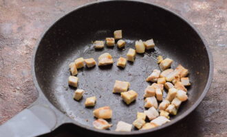 Sa parehong kawali, iprito ang bacon na hiwa sa maliliit na cubes.