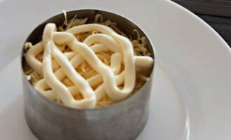Sau đó thêm phô mai bào và phủ sốt mayonnaise.