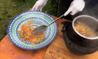 Haal de kruimelige pilaf, gekookt in een Afghaanse ketel boven een vuur, van het vuur, meng voorzichtig, doe het in een grote schaal en serveer voor de maaltijd. Eet smakelijk!
