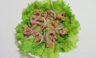 Ilagay ang mga dahon ng litsugas sa mga nakabahaging mangkok ng salad. Ilagay ang mga piraso ng tuna na may mga adobo na sibuyas sa ibabaw nito.