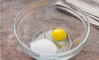 Trenqueu un ou en un plat amb costats alts, afegiu-hi dos tipus de sucre granulat i una mica de sal.