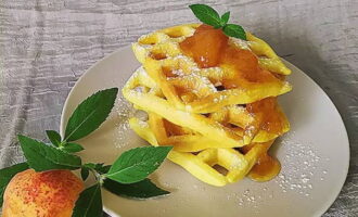 Bestrooi de wafels met poedersuiker en serveer met je favoriete jam.