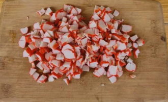 Alisin ang crab sticks mula sa shell at i-chop ayon sa gusto mo.