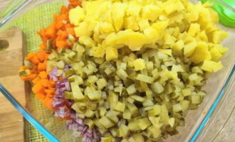 Gupitin ang karne ng manok, patatas, karot, sibuyas at atsara sa mga parisukat. Ilipat sa isang mangkok ng salad.