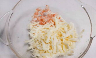 Într-un castron, combinați creveții cu două tipuri de brânză rasă.