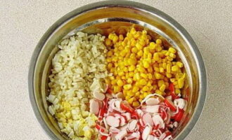 Đặt thanh cua, cơm, trứng và hạt ngô ngọt vào tô salad.