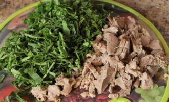 Thịt lợn luộc để nguội. Tách thịt ra khỏi xương. Chúng tôi cũng cắt cây me chua. Thêm cả hai sản phẩm vào súp sau khi khoai tây đã sẵn sàng.