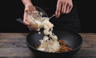 Thêm lượng gạo trong chảo vào, khuấy đều và đun dưới nắp thêm một phút nữa.