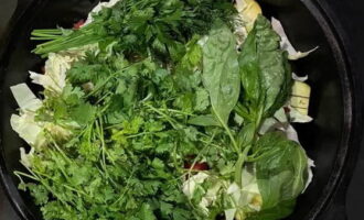 Ta bort vissnade blad från kål. Ta bort hela goda blad och ställ åt sidan. Grovhacka resterande kål och tillsätt salt och spiskummin. Lägg i en kittel. Täck toppen med klasar av grönska. Förslut med hela kålblad. Placera en vikt - en platt platta. Stäng locket ordentligt.