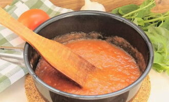 Verwarm de tomatenmassa op het fornuis. Voeg er zout, kruiden, olijfolie en gehakte knoflook aan toe. Kook en haal van het vuur.
