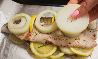 Vi gör små snitt i fisken. Sätt in citronskivor här.Lägg resterande lök på chumlaxen.