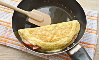 När ägget stelnat täcker du försiktigt fyllningen med en halv äggpannkaka.