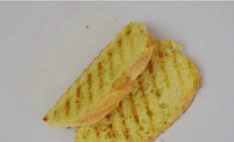 Droog de sneetjes brood zonder tijd te verspillen in een droge grillpan.