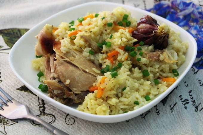 Pilaf met kip in een pan op het fornuis