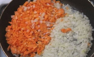 Lägg lök och morötter i en stekpanna med vegetabilisk olja.
