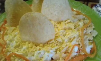 Cắt nhỏ lòng đỏ và phân phối ở lớp cuối cùng. Trang trí các mặt bằng cà rốt, như thể tạo thành một hòn đảo hoặc thành tàu. Đặt khoai tây chiên lên trên để tượng trưng cho cánh buồm.