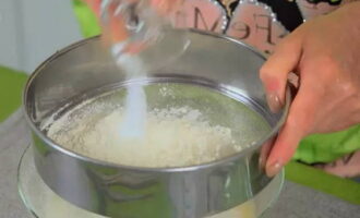 Cerne 150 de grame de făină de grâu și praf de copt într-o masă pufoasă.