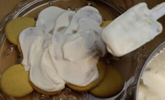 Așezați prăjiturile în straturi și cantități tot mai mici pe un vas, ungând generos fiecare strat cu smântână.