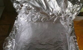Klä en bakplåt med aluminiumfolie för bakning.