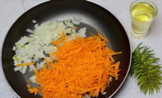 Piqueu la ceba i ratlleu les pastanagues. Posar en una paella amb oli vegetal.