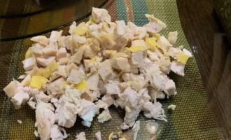 Överför kycklingen till en behållare för att montera aptitretaren. Skala äggen från deras skal. Skär ett ägg i tärningar och lägg till resten av ingredienserna.