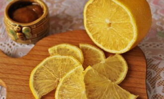 Banlawan at tuyo ang lemon. Gupitin ang citrus sa manipis na hiwa.