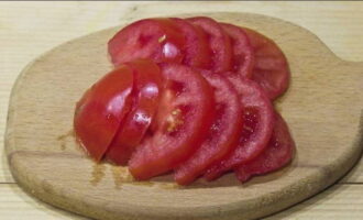 Skär den saftiga tomaten i kvartsringar.