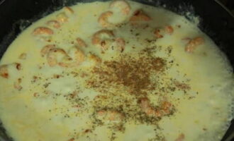 Apoi turnați laptele în creveți și adăugați un praf de mărar uscat, piper negru și nucșoară. Amesteca aceste ingrediente. Pune o bucată de unt și brânză topită tocată în sosul care fierbe. Amestecați din nou sosul pentru a se topi brânza.