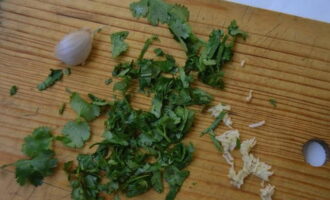 Cắt nhỏ ngò và tép tỏi bóc vỏ. Tỏi có thể được cho qua máy ép hoặc xay.