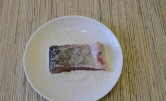 Lägg över bitarna till en tallrik med mjöl.