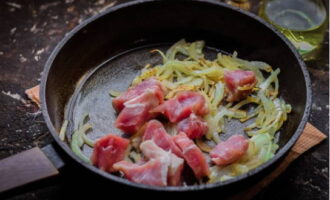 Adăugați carnea de porc în legumele aurii și prăjiți aproximativ 10 minute la foc mediu.