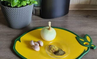 Skala löken och vitlöken. Förbered kryddorna.